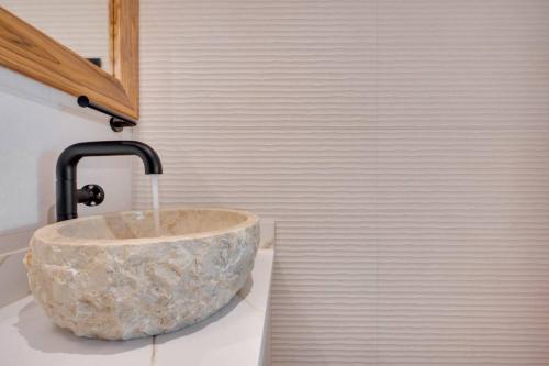 a bathroom with a stone sink with a faucet at Flamingo Marina Private Beachfront Escape in Playa Flamingo