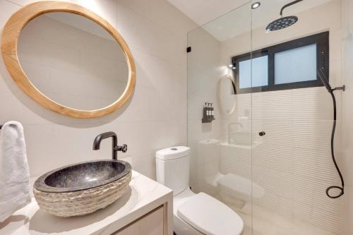 a bathroom with a sink and a toilet and a mirror at Flamingo Marina Private Beachfront Escape in Playa Flamingo