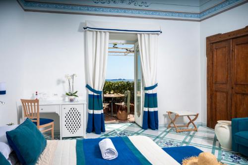 a bedroom with a bed with blue and white curtains at Albergo California in Positano