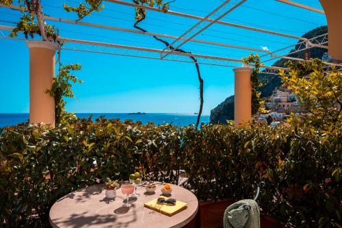 a table with wine glasses and a view of the ocean at Albergo California in Positano