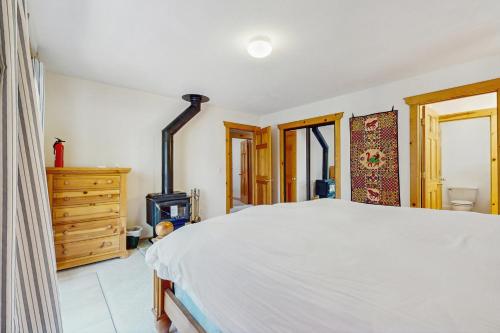 a bedroom with a white bed and a wooden dresser at The Tahoe House in Truckee