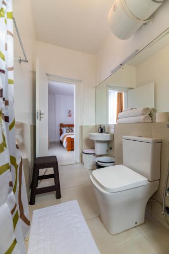 a white bathroom with a toilet and a sink at Lorien Homes in Nairobi