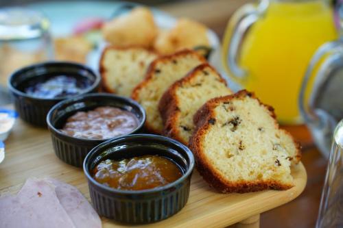 a cutting board with bread and some dipping sauces at Palorto Traditional Hotel in Gjirokastër