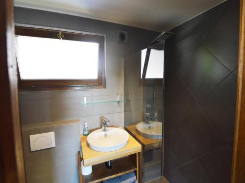 a bathroom with two sinks and a window at Comfortable Home with Sauna in Flobecq