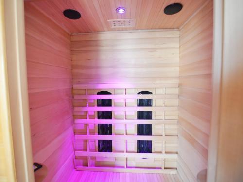 a sauna with pink lighting in a house at Comfortable Home with Sauna in Flobecq