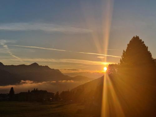 a sunset in the mountains with the sun setting at Sportpension Alpenrose in Schladming