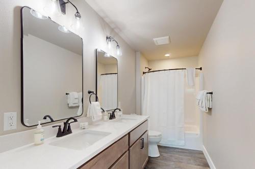 a bathroom with a sink and a toilet and a mirror at The Crossing at Lake Forest- 35 in Eagle River