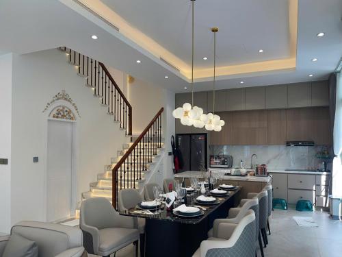 a kitchen with a long table with chairs and a staircase at La isla Apartments & Villas - Sea View & Fireworks Phu Quoc in Phu Quoc