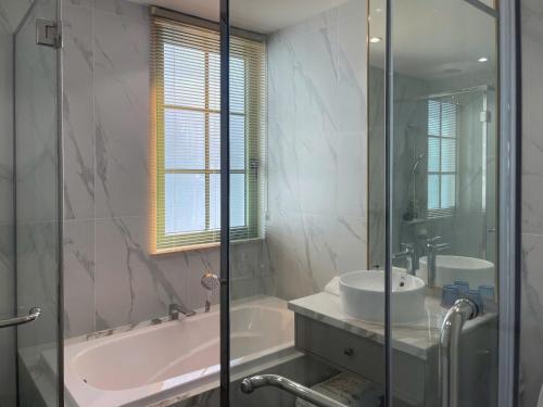 a bathroom with a tub and a sink and a shower at La isla Apartments & Villas - Sea View & Fireworks Phu Quoc in Phu Quoc