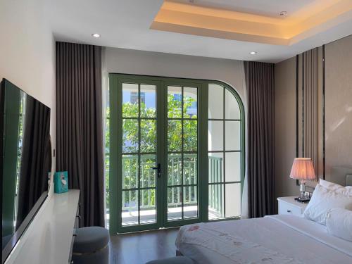 a bedroom with a bed and a large window at La isla Apartments & Villas - Sea View & Fireworks Phu Quoc in Phu Quoc