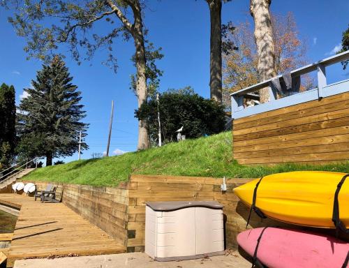 a house with a yellow kayak sitting next to a hill at Waterfront Suite with Dock, Firepit, BBQ in Newaygo