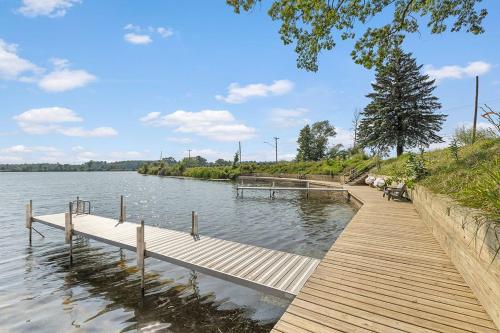 a wooden dock with a bench on the water at Waterfront Suite with Dock, Firepit, BBQ in Newaygo