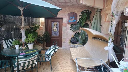 a patio with a table and chairs with an umbrella at Tryfonapartment school1922 in Krousón