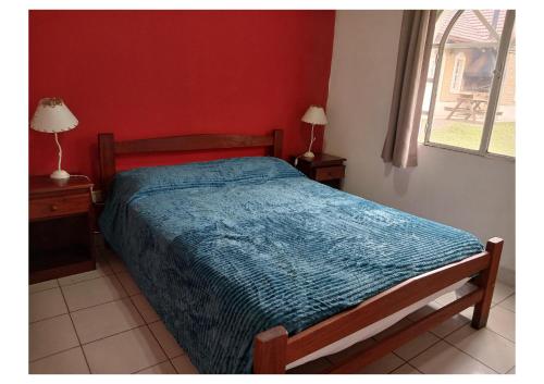 a bedroom with a bed with a blue comforter at Cabaña 5C Azahares del Ayui in Concordia