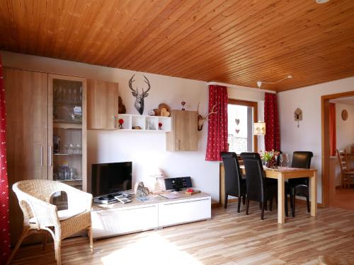 a living room with a desk and a table with chairs at Haus Jurisch in Urberg