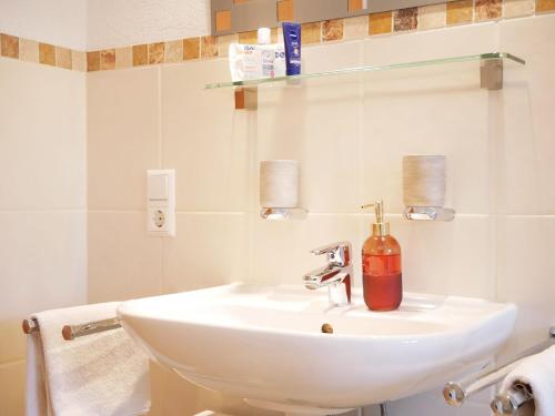 a bathroom with a sink with a soap dispenser on it at Haus Jurisch in Urberg