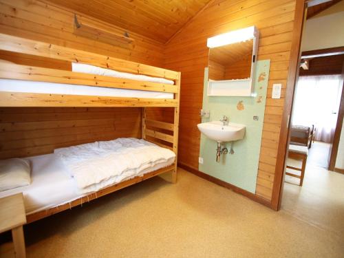 a bedroom with a bunk bed and a sink at Bright Chalet with Terrace in Randogne