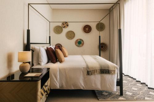 a bedroom with a bed and a table and a window at Our Habitas Ras Abrouq in Dukhān