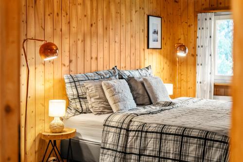 a bedroom with a bed with wood paneled walls at A&Y Chalet Davos Central in Davos