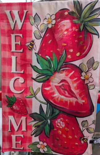 a pillow with strawberries on it next to a sign at いちごの里祭り村 in Shizuoka