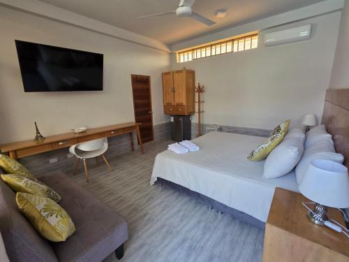 a hotel room with a bed and a couch at Posada Casa Bonita in Puerto Maldonado