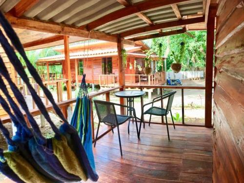 a wooden porch with chairs and a table on it at Wooden House Koh Lanta in Ko Lanta