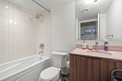 a bathroom with a tub and a toilet and a sink at Modern 1BD Apartment with Balcony DT Toronto in Toronto