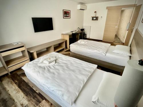 a hotel room with two beds and a television at OH Apartments & Rooms in Ljubljana