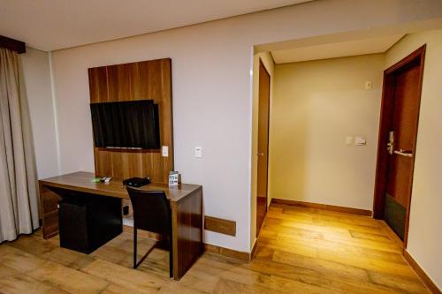a room with a desk and a room with a door at Padom Business Hotel in Bragança Paulista