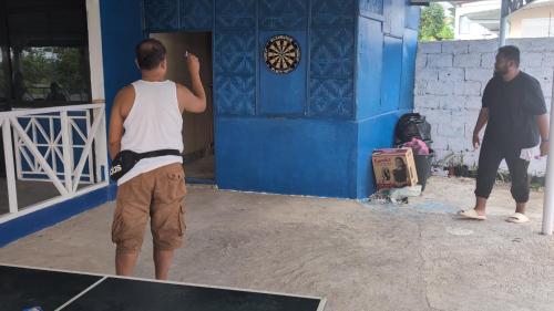 two men standing outside of a blue building at B'lu Bamboo in Moalboal