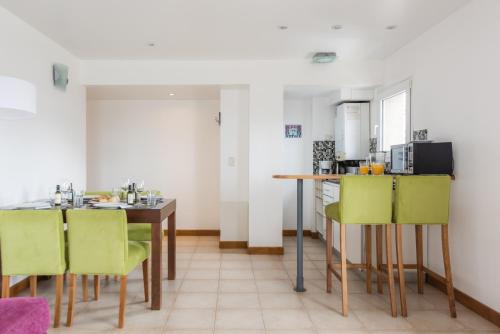 a kitchen with a table and some green chairs at Cilene del Faro Suites & Spa in Ushuaia
