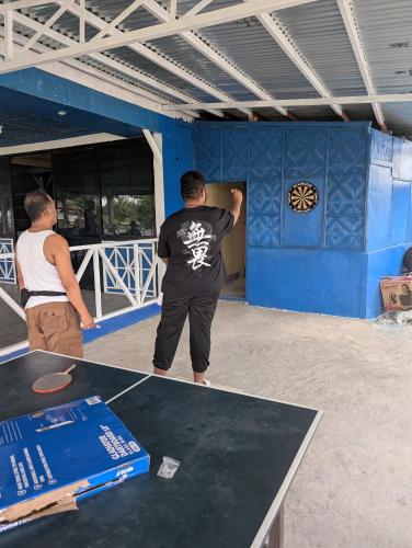 two men painting a blue wall in a room at B'lu Bamboo in Moalboal