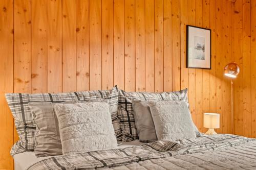 a bedroom with a bed with pillows and a wooden wall at A&Y Chalet Davos Central in Davos