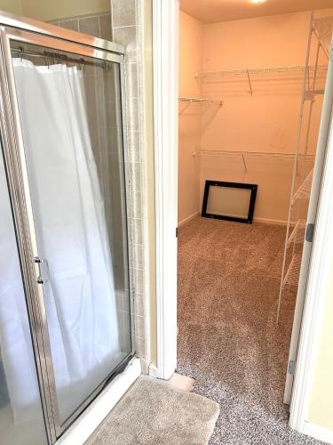 a walk in shower in a room with a glass door at la paz private room with jacuzi in Fresno