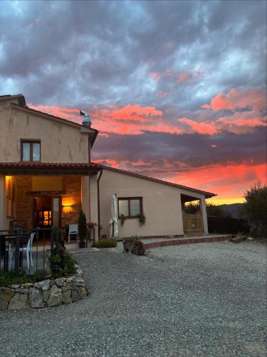 a house with a sunset in the background at Agriturismo Millennial in Quarrata