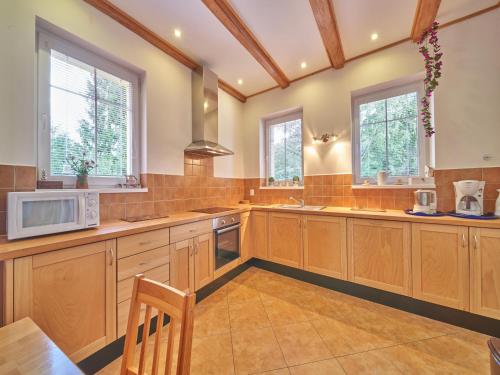 a large kitchen with wooden cabinets and windows at Spacious Mountain Retreat in Lampertice