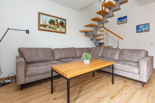 a living room with a couch and a table at Apartamentai NEMUNAS in Pervalka