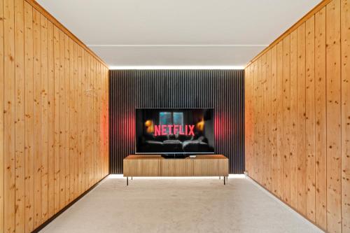 a living room with a tv on a wall at A&Y Chalet Davos Central in Davos