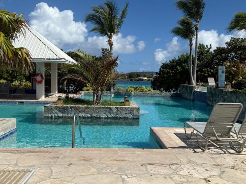 a swimming pool with two lounge chairs in a resort at C206 - Sapphire Beach - Sapphire Jewel VI in East End