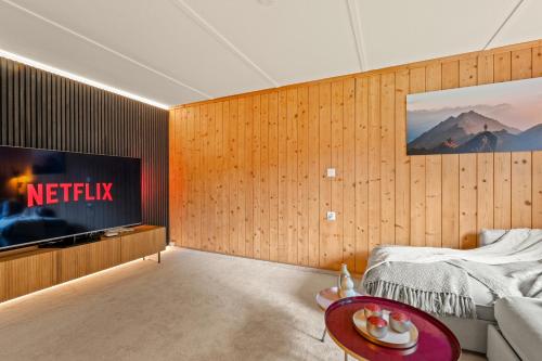 a living room with a television and a bed at A&Y Chalet Davos Central in Davos