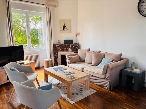 a living room with a couch and a table at Maison proche centre Carantec in Carantec