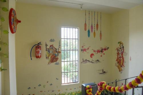 a room with a wall with decorations on it at Namaskar Lodge and Homestay in Guwahati