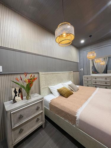 a bedroom with a bed and a vase of flowers at Bà Nữ Apartment in Soc Trang