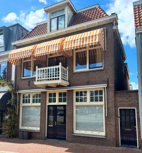 a brick house with a balcony on top of it at Luxury Family Apartment with canal & Peperbus view in Zwolle