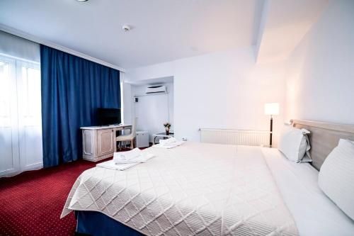 a hotel room with a large bed and a television at Visconti Militari in Bucharest