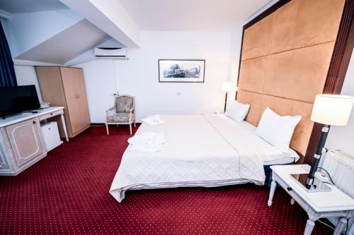 a hotel room with a large bed and a television at Visconti Militari in Bucharest