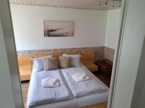 a bedroom with a bed with white sheets and pillows at Ferienhaus Eder Denk in Illmitz