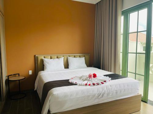 a bedroom with a bed with a flower arrangement on it at La isla Apartments & Villas - Sea View & Fireworks Phu Quoc in Phu Quoc