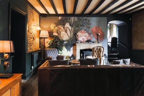 a living room with a couch and a fireplace at The Bull Hotel in Fairford