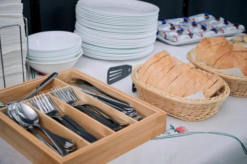 a table with a wooden tray of utensils and plates at Visconti Militari in Bucharest